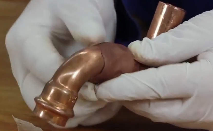 Epoxy Copper Repair Putty being applied to a leak on a copper water pipe